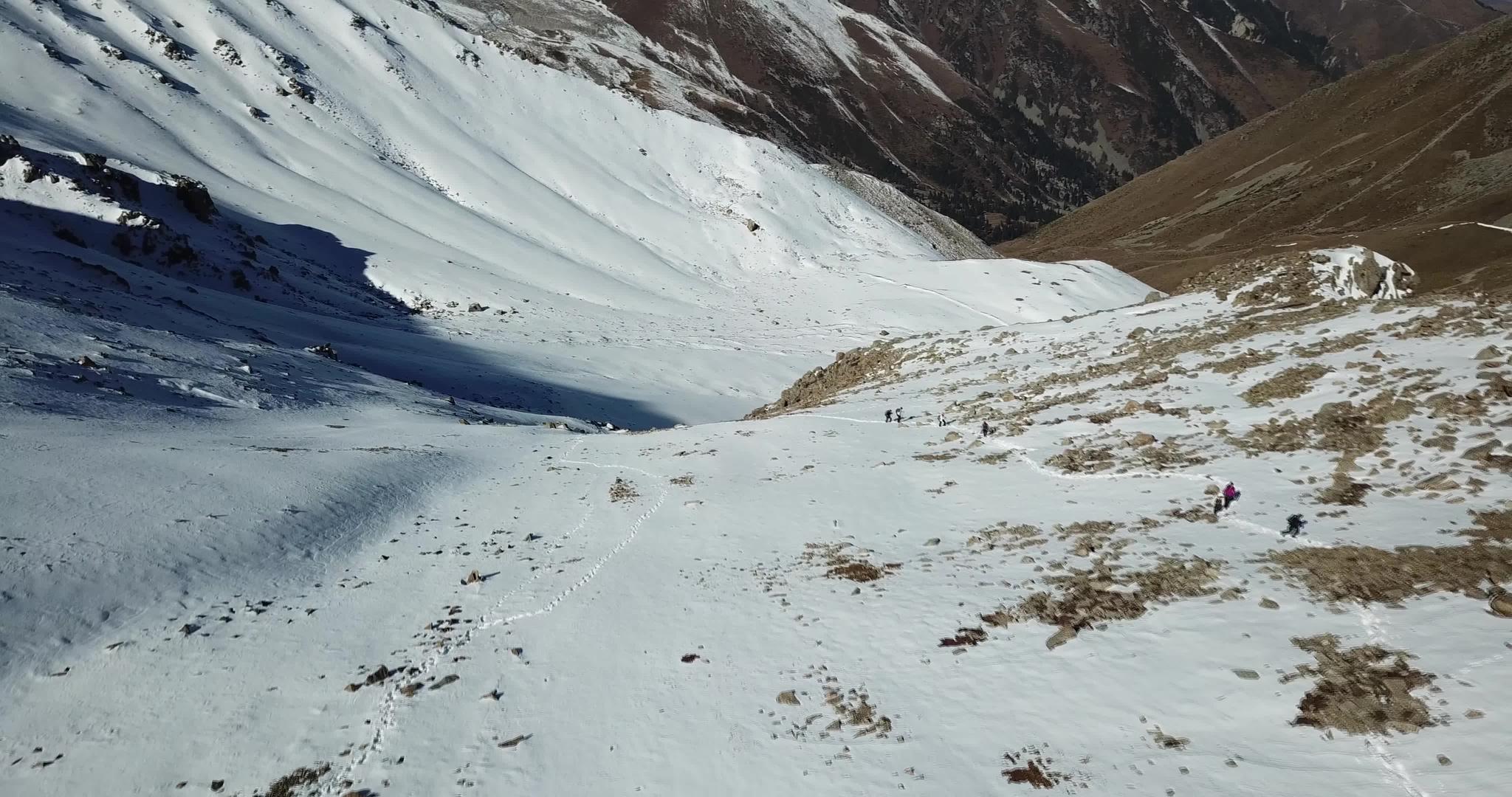 观光游客沿着山上的雪路行走视频的预览图