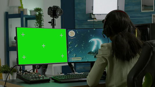 非洲女性玩家使用绿色模拟桌面在电脑上玩游戏视频的预览图