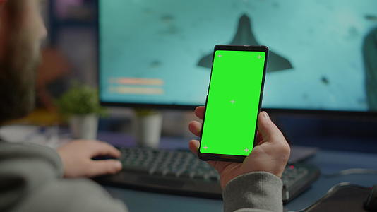 在绿色屏幕上观看智能手机的竞技游戏视频的预览图
