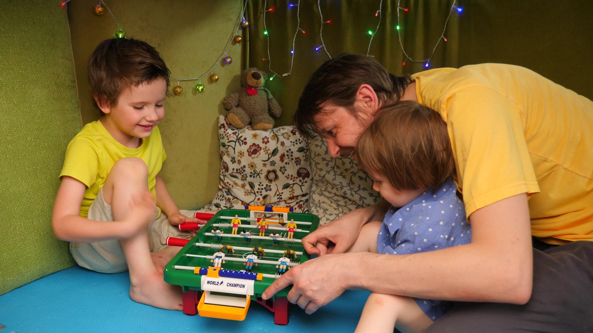 父亲带着孩子在室内桌子上玩足球家庭花时间在家快乐的孩子视频的预览图