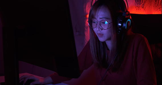 年轻的亚洲女性玩在线视频游戏射击fps视频的预览图