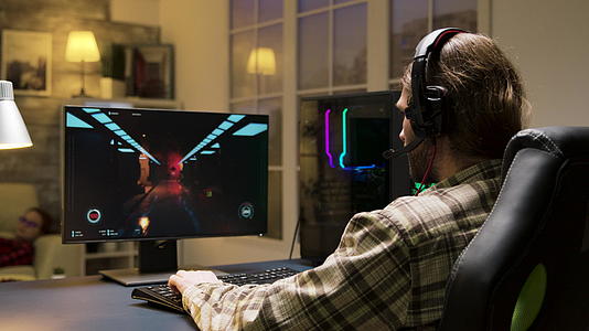 男人用耳机在网上玩电子游戏视频的预览图