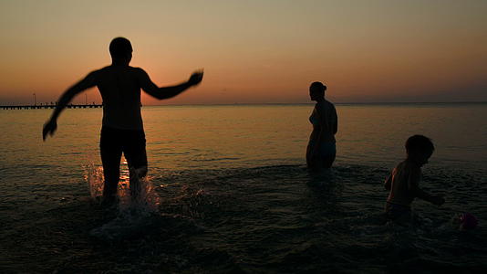 日落时家人在海里洗澡视频的预览图