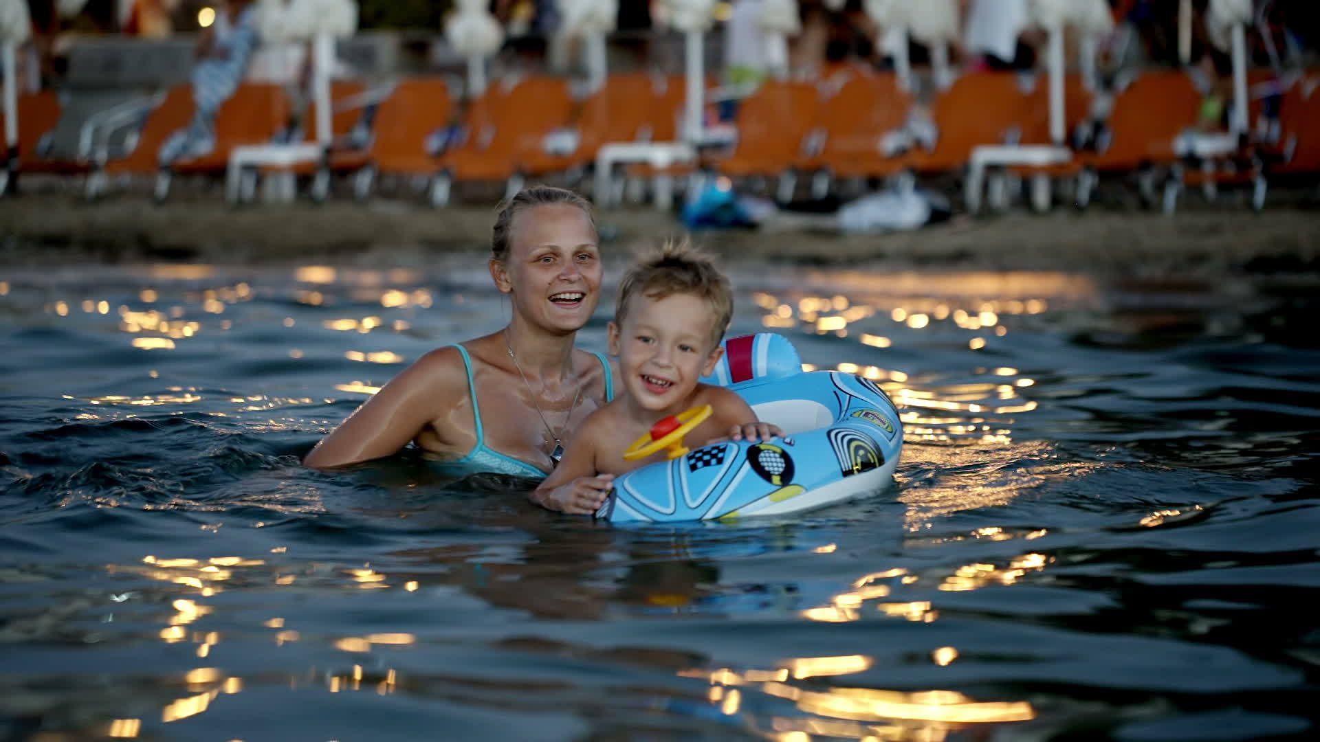 儿子带着橡皮环和母亲在海上洗澡视频的预览图