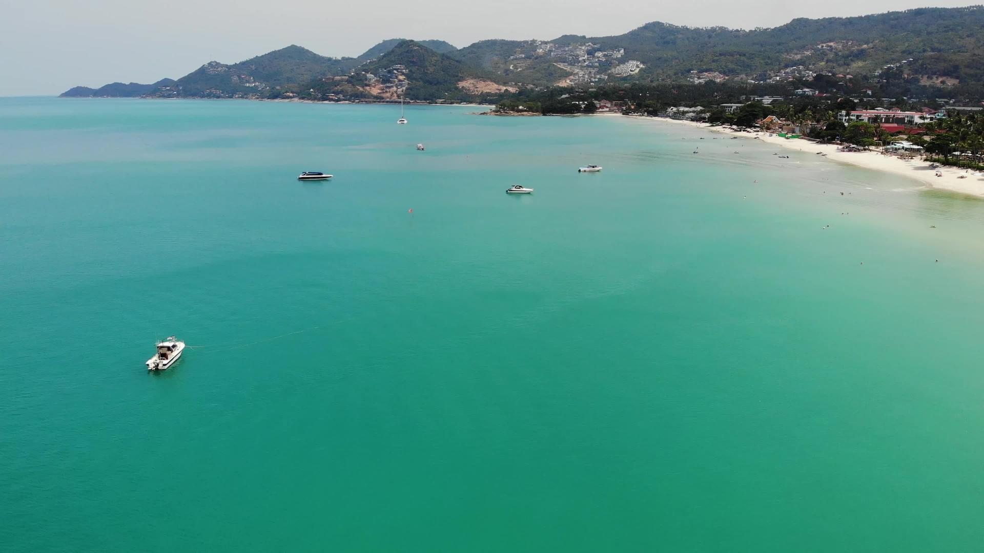 现代摩托车游艇漂浮在阳光明媚的热带度假胜地海滩附近视频的预览图