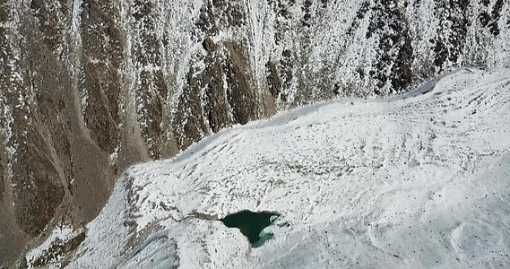 峡谷中的冰湖在岩石和雪之间视频的预览图