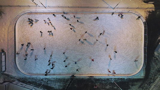 晚上一群人在明亮的溜冰场上从上到下垂直滑冰视频的预览图