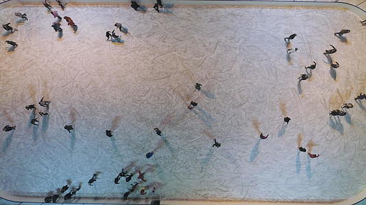 晚上人们在灯火通明的溜冰场上建立了滑冰的垂直俯视图视频的预览图