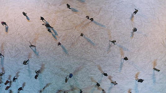 晚上人们在灯火通明的溜冰场滑冰中垂直俯视建立射击视频的预览图