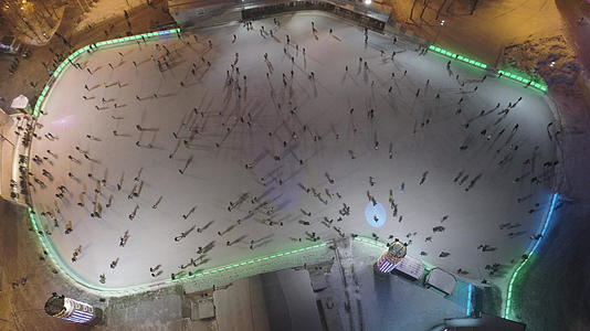 晚上当人们在大型照明溜冰场滑冰时空气是垂直的视频的预览图
