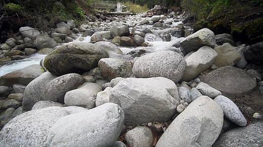 秋天的森林沿着山脉和河流缓慢移动的大型弯曲的石头和岩石视频的预览图