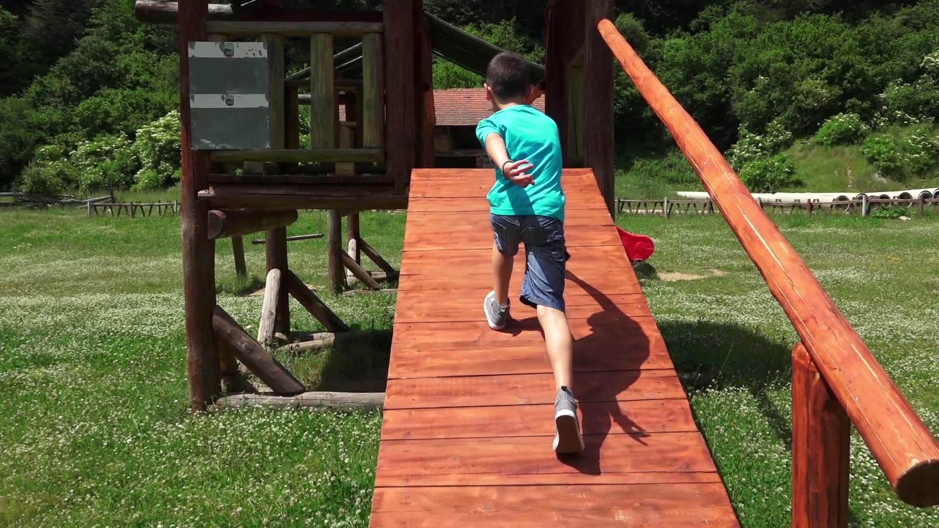 快乐的男孩在木屋里滑行在户外公园里滑行玩慢动作视频的预览图