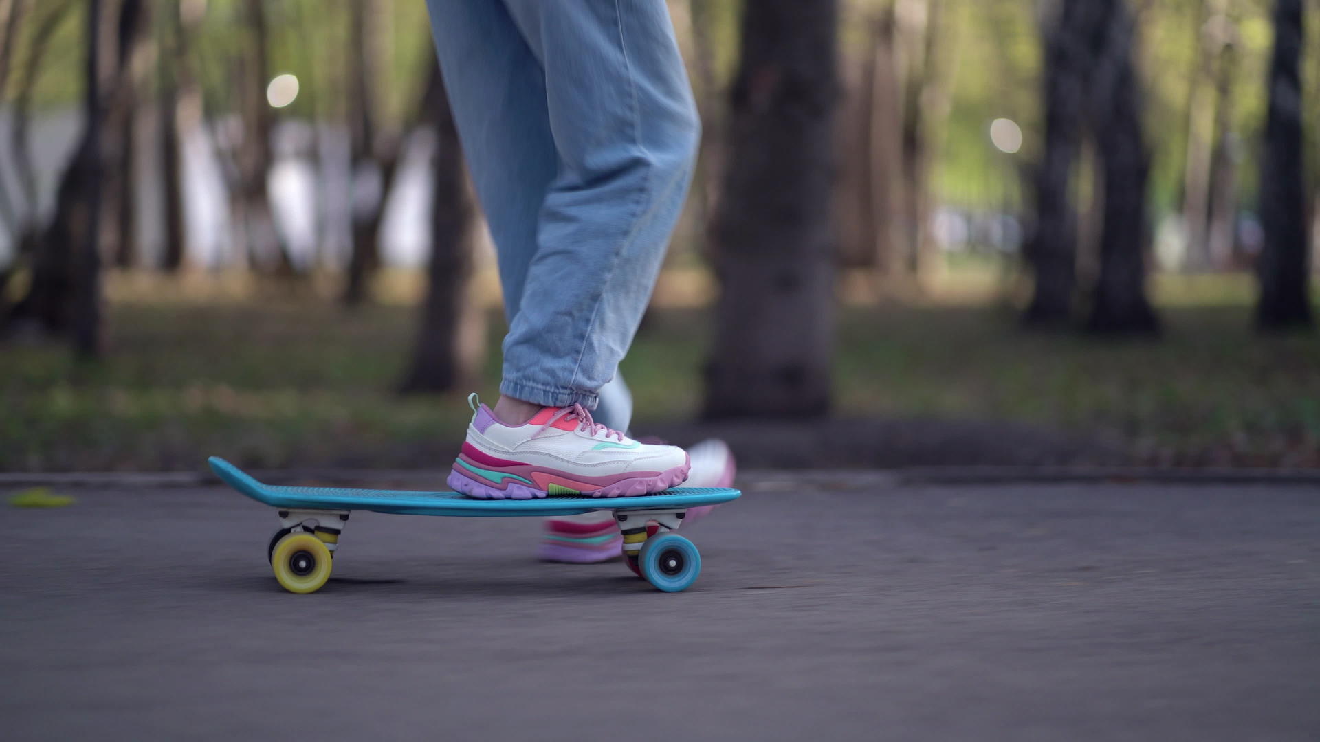 在滑板上收紧双腿在公园里沥青运动视频的预览图