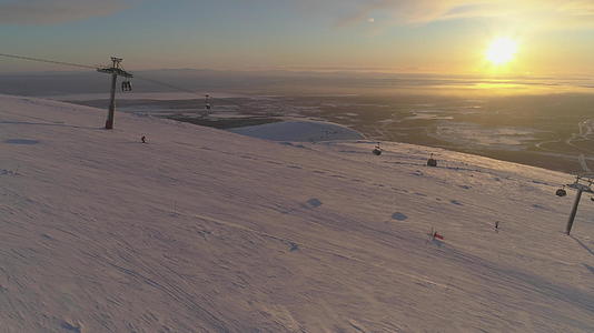 在阳光明媚的冬日夕阳下人们在滑雪坡上滑雪和滑雪板滑雪视频的预览图
