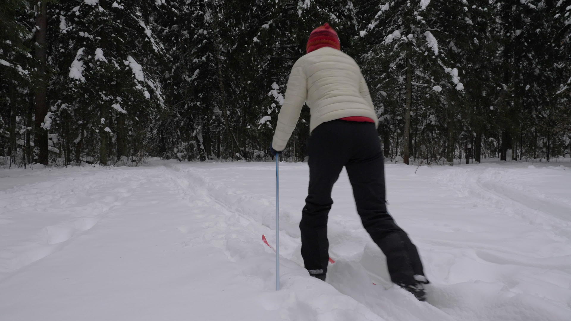 在冬天年轻女子在森林里滑雪用相机拍摄慢动作全拍笑声视频的预览图