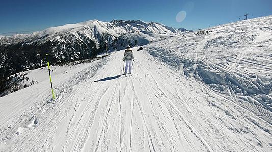 跟踪一个有魅力的女人在高山高度滑雪路上视频的预览图