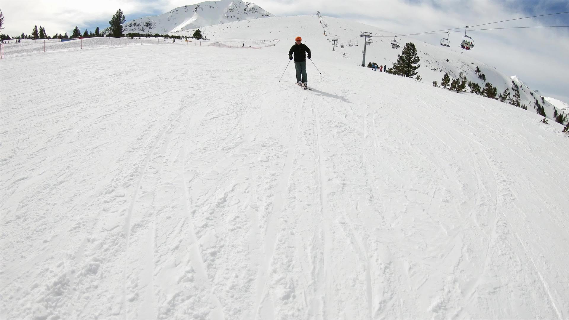 高山滑雪胜地在高山脚下的悬崖上骑着滑雪车视频的预览图