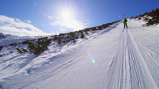 在阳光明媚的冬天在滑雪电梯上滑雪视频的预览图