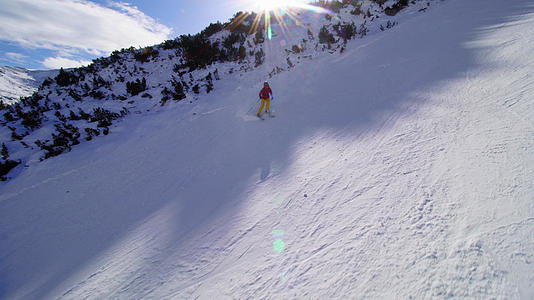 中产阶级女性滑雪者在阳光明媚的一天在斜坡上滑雪视频的预览图