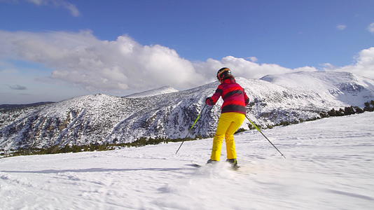中产阶级女性滑雪者在阳光明媚的一天在斜坡上滑雪视频的预览图