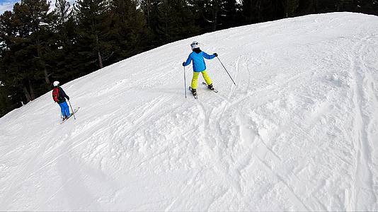 在山坡上慢慢滑雪时用安全头盔护目镜和杆子跟踪一个视频的预览图