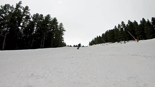 前视跟踪滑雪者慢慢地用橙色头盔从滑雪坡上下来视频的预览图
