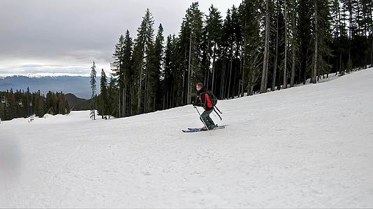 跟踪滑雪者的镜头橙色头盔从滑雪坡上慢慢下来视频的预览图