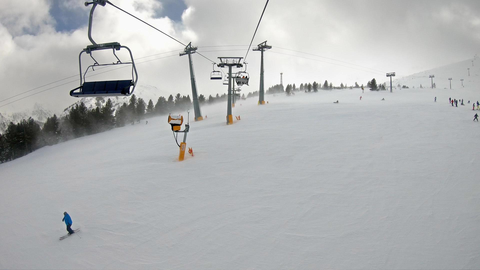 从滑雪缆车的第一个角度来看山峰上的床上天气滑雪场上的雪漂流强风视频的预览图