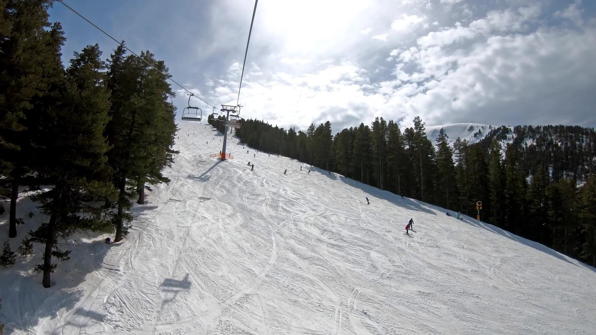 在布尔加里亚的班特科滑雪胜地滑雪机和滑雪机从椅子上吊起在空中视频的预览图