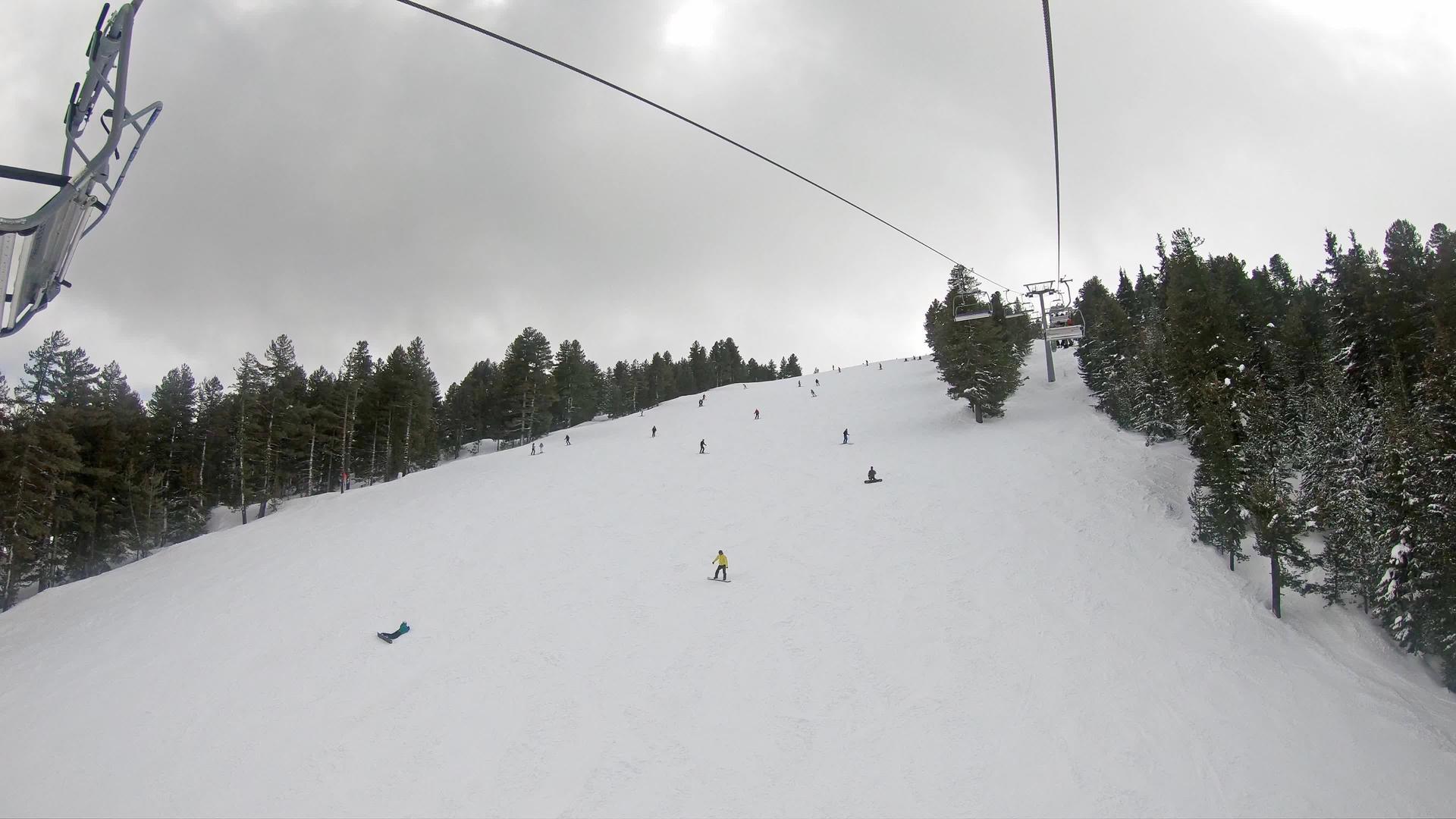 滑雪者和滑雪者在晴朗的天空中从第一个角度慢慢移动视频的预览图