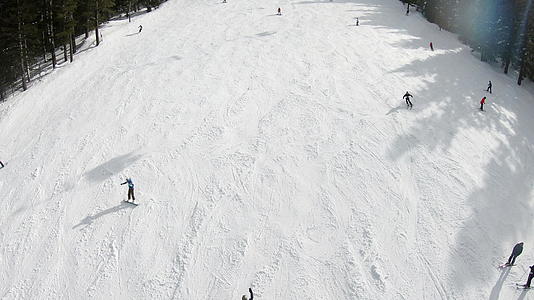 观察明天阳光滑雪山坡上滑雪者和滑雪者的空气视频的预览图