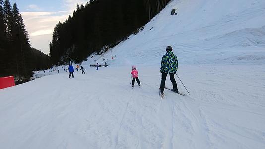 冬天父亲和孩子在滑雪道上滑雪父亲给了他的孩子视频的预览图