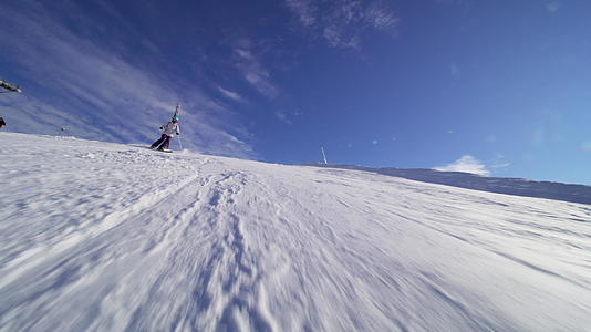 在斜坡上滑雪的女孩滑雪者可以在沙丘的阳光和耀斑中看到视频的预览图