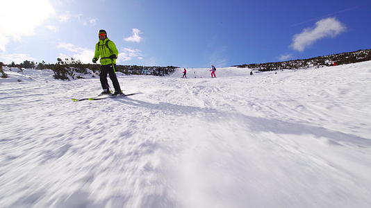 男性滑雪者在阳光明媚的一天在斜坡上滑雪视频的预览图