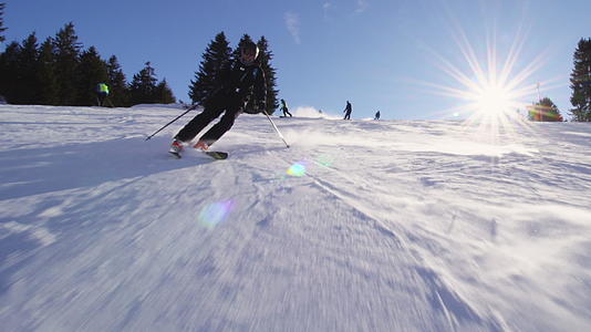 在瑞士阿尔卑斯山的斜坡上男性滑雪者可以看到阳光和耀斑视频的预览图