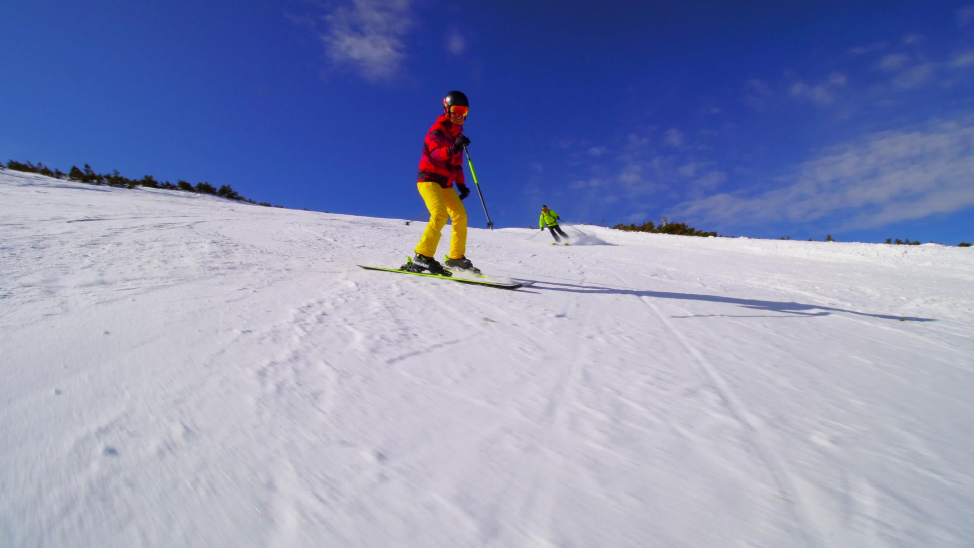朋友们在阳光明媚的冬天在山坡上滑雪视频的预览图