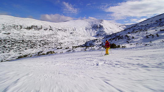 朋友们在阳光明媚的冬天在山坡上滑雪视频的预览图