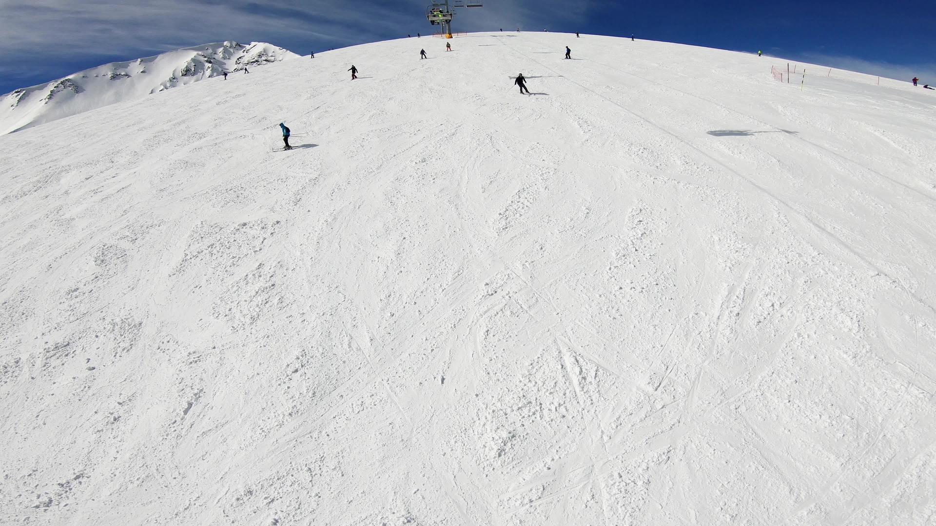 滑雪者和单板滑雪者享受山顶冬季度假村的滑雪坡视频的预览图