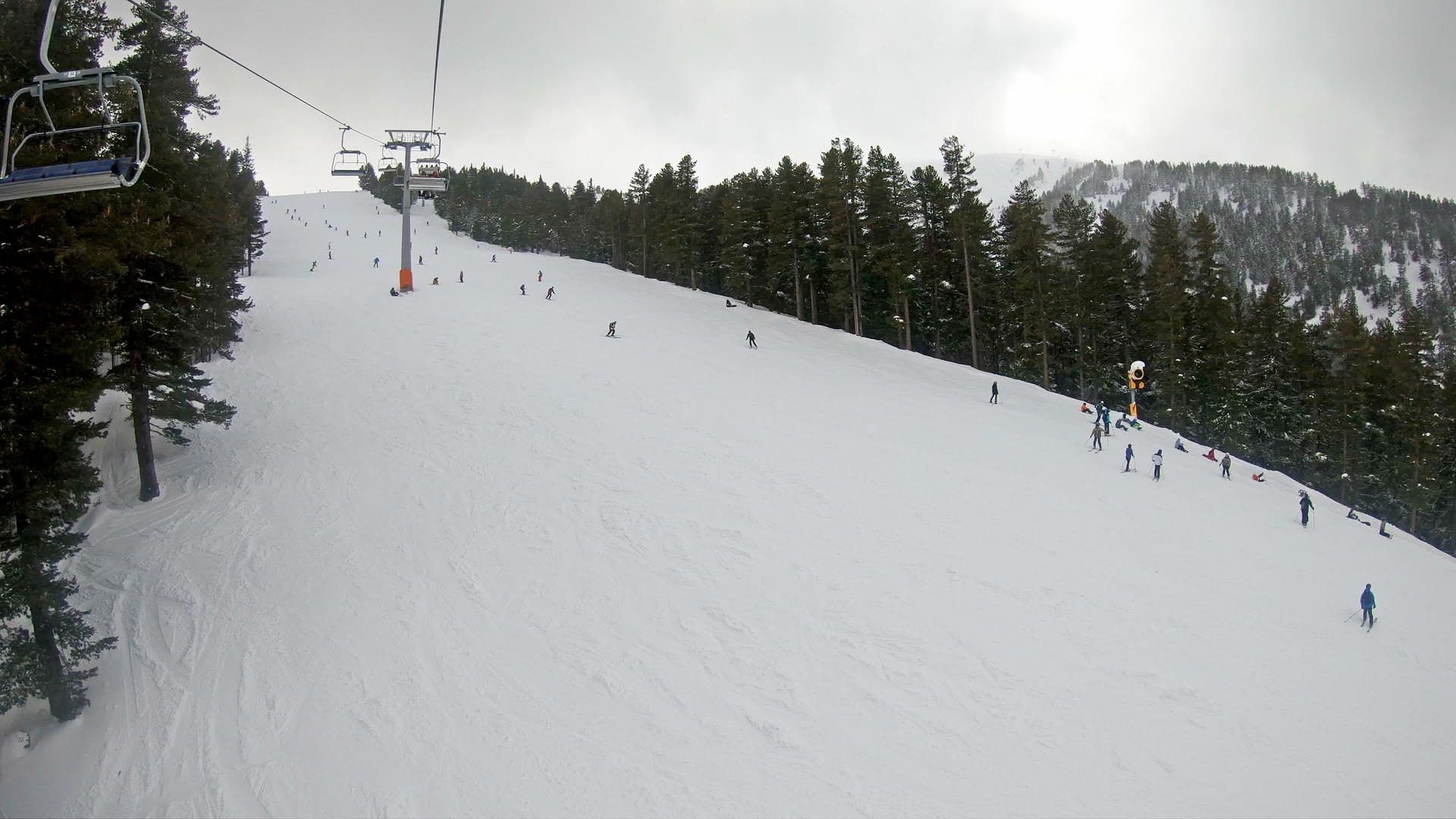 在阳光明媚的冬天滑雪者骑着椅子升降机慢慢移动视频的预览图