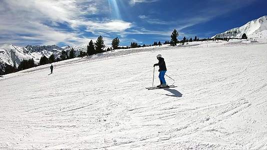 在阳光明媚的一天滑雪和超慢动作后的侧视图视频的预览图