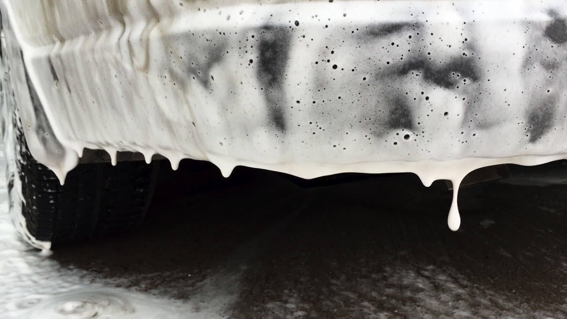 脏洗车的白色泡沫泡沫滑落在地板洗发水上视频的预览图