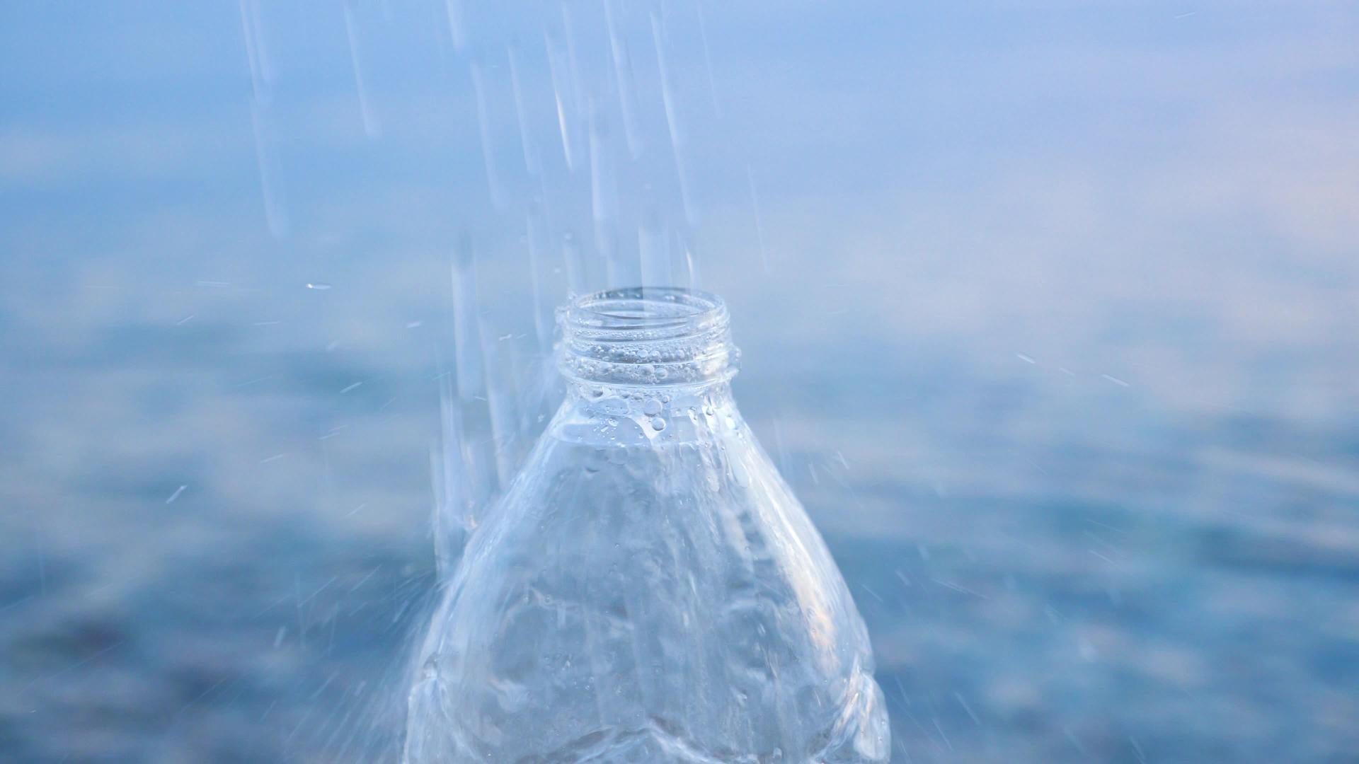 天然饮用纯净水落在PET瓶子上的水滴漂亮的水滴倒进瓶子里视频的预览图