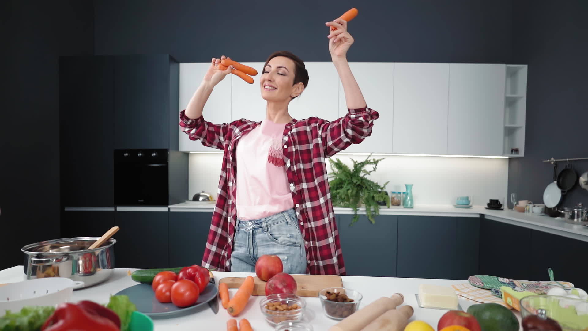 在新房子的新厨房里女人们手里拿着胡萝卜享受着幸福的家庭生活视频的预览图