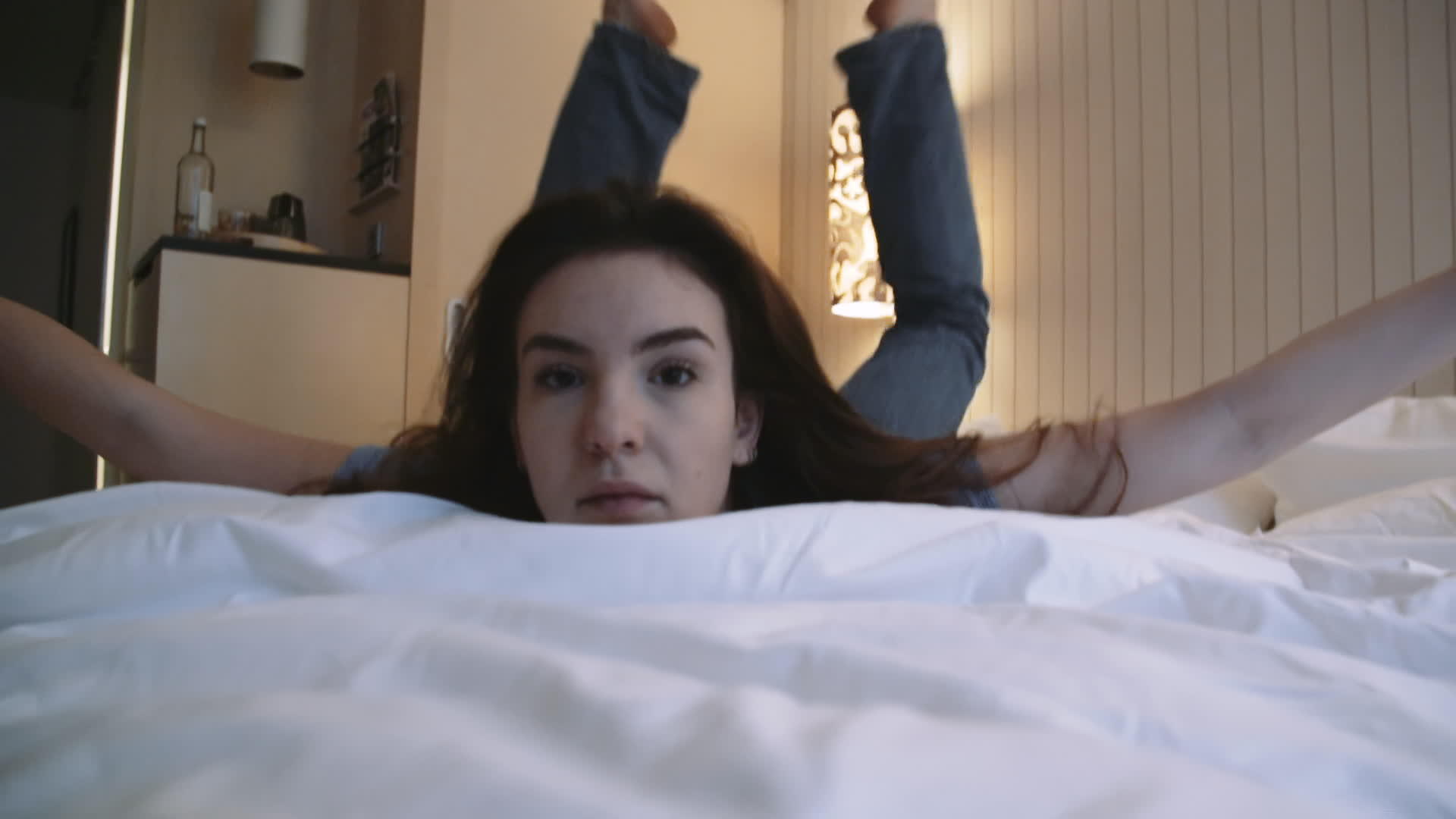 年轻女士躺在床上看着镜头抬头看着镜头视频的预览图