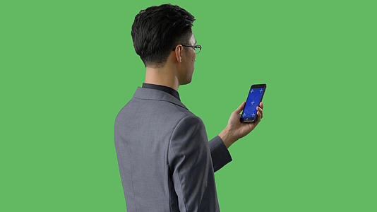 4k绿幕合成抠像商务男性使用蓝幕手机背影视频的预览图