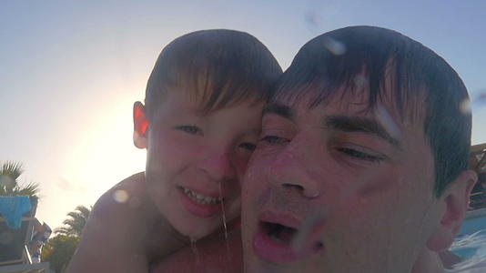 父亲教他的儿子在游泳池潜水视频的预览图
