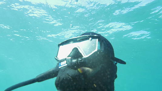 潜水员在阳光明媚的蓝色水域潜水视频的预览图