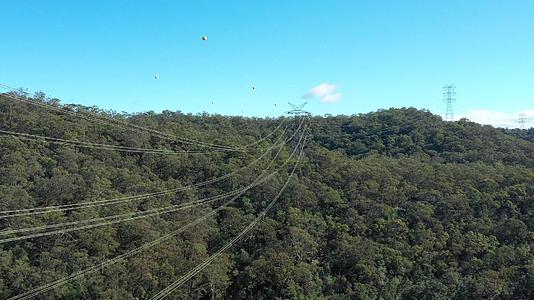 输电塔电力线横跨河流的空中飞行视频视频的预览图