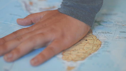 她的手覆盖着五颜六色和模糊的奥斯特拉利亚地图视频的预览图