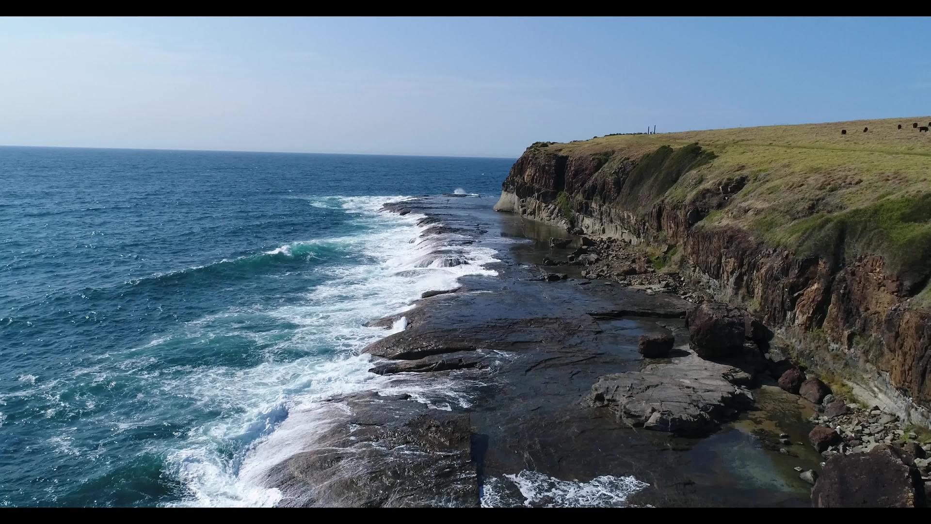 在澳洲地区Kiama海浪落在附近海岸的空中视频的预览图